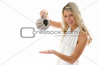The young attractive girl pours milk from a jug
