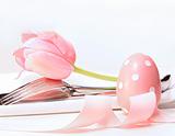 Closeup of tulip and utensils on pale pink