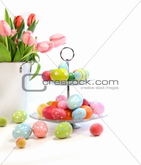 Colorful easter eggs with pink tulips on white