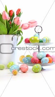 Pink tulips with colorful easter eggs on white