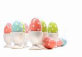 Polka dot easter eggs in cups on white