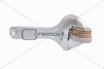 Steel wrench with coins isolated on white background