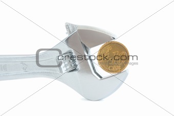 Steel wrench with coin isolated on white background