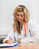 Blonde doctor writing a report