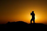 A silhouette of cameraman with golden light in the morning.