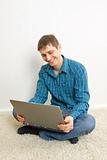 man sitting on the floor using a laptop