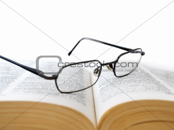 Opened book with glasses