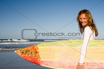 Girl standing with surfboard