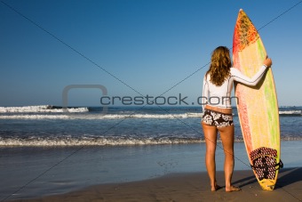 Girl standing with surfboard