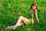 Young beautiful girl sitting on the grass