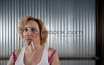Woman smoking in front of corrugated metal