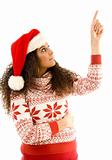 cute young woman wearing red christmas hat and pointing upwards