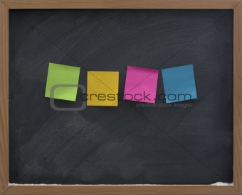blank, colorful sticky notes on blackboard