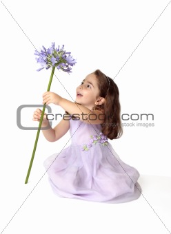 Little girl spinning a large stemmed flower with delight
