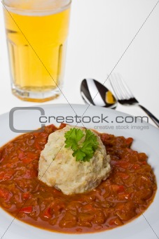 hungarian goulash and a bread dumpling on a white plate