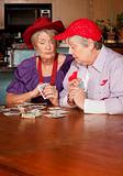 Ladies wearing red hats playing cards