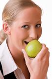 Young woman is eating a green apple