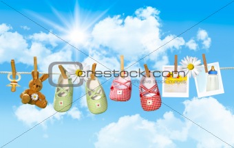 Baby shoes, pacifier and teddy bear on clothesline