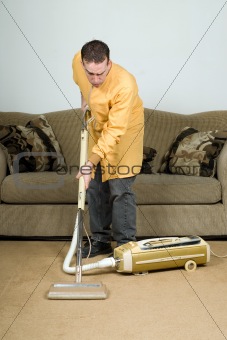 Man Vacuuming The Carpet