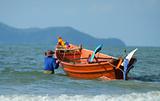 Fisherman taking his boat to sea