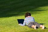 girl laying in the grass with laptop
