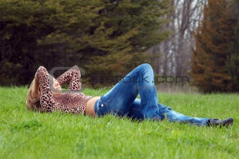 cheerful girl laying on the green grass.