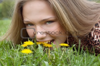 pretty girl fooling around (biting dandelionm)