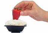 Woman hand strawberry over cream