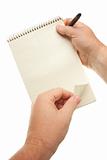 Male Hands Holding Pen and Pad of Paper Isolated on a White Background.