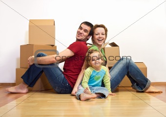 Happy family in their new home with cardboard boxes