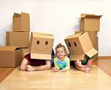 Family playing with cardboard boxes in their new home