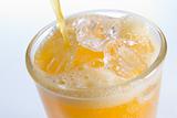 Pouring Orangeade Into A Glass Of Ice