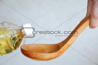 Pouring oil in wooden spoon