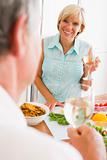 Woman Talking To Husband As She Prepares A meal,mealtime