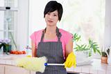 Woman Holding Duster And Wearing Rubber Gloves Not Looking Impre