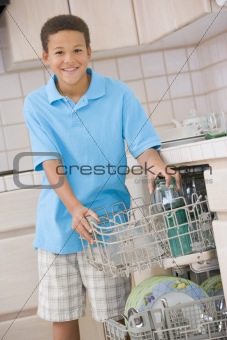 Young Boy Loading Dishwasher