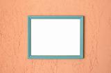 Photo frame on brightly coloured pink stucco wall.