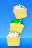 Three delicious vanilla cupcakes with buttercream frosting stack