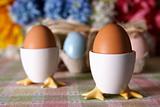 Colored Easter Eggs In Egg Cups ~ Fresh Flowers In Background