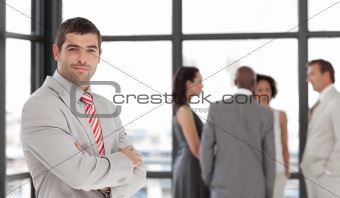 Senior Business Man with arms folded in Front of team
