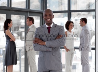 Potrait of a Business man standing smiling in front of team 