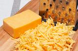 Grated cheddar cheese on wooden board