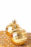 Two gold Christmas baubles on pretty material