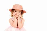 Portrait of young girl in pink princess dress and hat with hands on face, studio shot