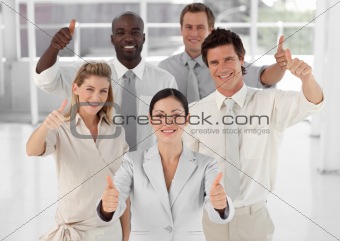 Business Team Smiling and Holding up Thumbs to camera