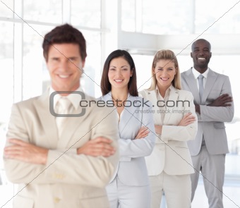Business man with arms folded in front of Business Team 