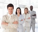 Business man with arms folded in front of Business Team 