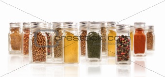 Assorted spice bottles isolated on white