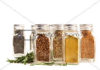 Spice jars with fresh rosemary leaves against white