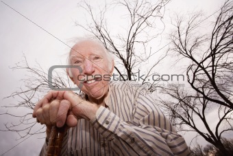 Old man in front of bare trees